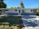 Ranch-style home with a white facade, gray brick, and a concrete driveway under a bright blue sky at 7123 Winona Ct, Westminster, CO 80030