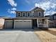 Charming two-story home featuring a three-car garage, stone accents, and a welcoming front porch at 24770 E 39Th Ave, Aurora, CO 80019