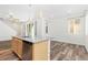 Kitchen island with a stainless steel dishwasher and sink, light wood cabinets, and open view into the living room at 5319 Warrior St, Frederick, CO 80504