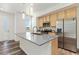 Modern kitchen with a large island, stainless steel appliances, and wood cabinets at 5319 Warrior St, Frederick, CO 80504