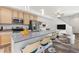Spacious kitchen with a large island, stainless steel appliances, and breakfast bar adjoining the dining and living areas at 5319 Warrior St, Frederick, CO 80504