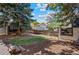 Landscaped backyard features a wooden fence, mature trees, and a charming deck, offering a private outdoor space at 7633 Gray Way, Arvada, CO 80003