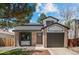 Charming two-story home featuring a brick facade, well-manicured lawn, and attached garage at 7633 Gray Way, Arvada, CO 80003