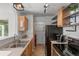 Efficient kitchen featuring stainless appliances, floating shelves, and convenient in-unit laundry area at 7633 Gray Way, Arvada, CO 80003