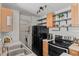 Efficient kitchen featuring stainless appliances, floating shelves, and convenient in-unit laundry area at 7633 Gray Way, Arvada, CO 80003