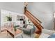 Open-concept living space with wooden floors, a staircase, and seamless flow to the dining area at 7633 Gray Way, Arvada, CO 80003