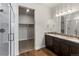 A bright bathroom features a granite-topped double vanity, walk-in closet, and a glass-enclosed shower at 2149 Peralta Loop, Castle Rock, CO 80104