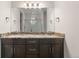 Bathroom featuring granite counters, dark cabinets, double sinks and a shower with a glass door at 2149 Peralta Loop, Castle Rock, CO 80104