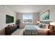 Staged bedroom with a large bed, modern furniture, and a bright window with neighborhood views at 2149 Peralta Loop, Castle Rock, CO 80104