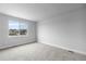 A well-lit room with carpet flooring and a large window framing the neighborhood view at 2149 Peralta Loop, Castle Rock, CO 80104
