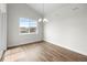 Bright dining room with wood floors, a modern chandelier, and a large window offering neighborhood views at 2149 Peralta Loop, Castle Rock, CO 80104