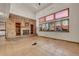 Bright living room with a brick fireplace, built-in shelves, and large windows providing ample natural light at 5863 S Danube St, Aurora, CO 80015