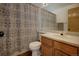 A functional bathroom features a vanity, toilet, sink, and patterned shower curtain in neutral colors at 22739 E Prentice Pl, Aurora, CO 80015