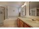 The bright bathroom showcases a double vanity, a soaking tub with shower, and tiled flooring at 22739 E Prentice Pl, Aurora, CO 80015