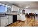An open kitchen featuring white cabinetry, hardwood floors, and an adjacent dining and living area at 22739 E Prentice Pl, Aurora, CO 80015