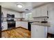 Bright kitchen featuring white cabinetry, stainless steel appliances, and hardwood floors at 22739 E Prentice Pl, Aurora, CO 80015