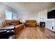 Bright living room features hardwood floors, leather furniture, a fireplace and a large window at 22739 E Prentice Pl, Aurora, CO 80015