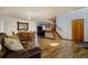Comfortable living room with hardwood floors, a leather couch, and staircase leading to the second floor at 22739 E Prentice Pl, Aurora, CO 80015