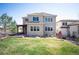 Exterior of the home featuring a well-maintained lawn, back patio with pergola, and charming architectural details at 2559 S Kendrick St, Lakewood, CO 80228