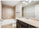 Well-lit bathroom featuring a shower-tub combo, tile surround and modern vanity at 2559 S Kendrick St, Lakewood, CO 80228