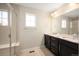 Bright bathroom featuring a double sink vanity with granite countertop and a glass enclosed shower at 2559 S Kendrick St, Lakewood, CO 80228