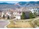 Charming two-story home showcasing red shutters, tile roof, and mountain views in a peaceful neighborhood at 2559 S Kendrick St, Lakewood, CO 80228