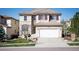 Two-story home featuring a two-car garage, red shutters, stone accents, and a well-maintained front lawn at 2559 S Kendrick St, Lakewood, CO 80228