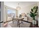 Sunlit home office featuring modern furnishings, a decorative chandelier, and a large window at 2559 S Kendrick St, Lakewood, CO 80228