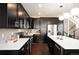 Modern kitchen with dark cabinets, stainless steel appliances, white countertops, and hardwood flooring at 2559 S Kendrick St, Lakewood, CO 80228