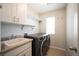 Functional laundry room with modern washer and dryer, sink, and built-in shelving for storage at 2559 S Kendrick St, Lakewood, CO 80228