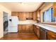 Kitchen with wood cabinets, white appliances, and wood floor at 6740 S Clarkson St, Centennial, CO 80122