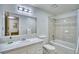 Bright bathroom with a shower and tub combination featuring neutral tile and a large mirror at 10342 Monterey Cir, Northglenn, CO 80260
