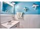 Bright bathroom with white wainscoting, blue walls, and a decorative mirror at 10342 Monterey Cir, Northglenn, CO 80260