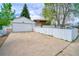 Spacious driveway leading to a detached garage, enclosed by a white picket fence at 10342 Monterey Cir, Northglenn, CO 80260