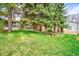 Charming front yard with mature trees and green lawn of a cozy house at 10342 Monterey Cir, Northglenn, CO 80260