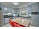 Well-lit kitchen with stainless appliances, a central table with seating, and tiled flooring at 10342 Monterey Cir, Northglenn, CO 80260
