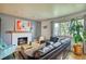 Cozy living room featuring a fireplace, large window, and a comfortable leather sectional sofa at 10342 Monterey Cir, Northglenn, CO 80260