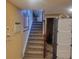 Carpeted stairway offers secure passage between floors with a wooden handrail, enhancing safety at 2190 S Holly St # 213, Denver, CO 80222