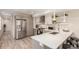 Open kitchen with stainless steel refrigerator, white countertops, and breakfast bar seating at 1318 Yates St, Denver, CO 80204