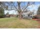 Spacious backyard showcasing a mature tree, swing, dining area, and covered patio at 3966 S Magnolia Way, Denver, CO 80237