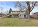 Large backyard featuring a patio, mature trees, and a well-maintained lawn perfect for outdoor enjoyment at 3966 S Magnolia Way, Denver, CO 80237