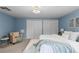 Bedroom featuring carpeted floor, white bed, double closet doors, and sitting chair at 3966 S Magnolia Way, Denver, CO 80237