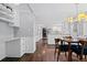 Open dining area features hardwood floors, a wooden table, and bright white accents with modern lighting at 3966 S Magnolia Way, Denver, CO 80237