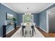 Dining room with a dark wood table, chandelier, neutral walls and hardwood floors, adjacent to door at 3966 S Magnolia Way, Denver, CO 80237