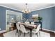 Dining room with a wood table, chandelier, neutral walls and hardwood floors, adjacent to living area at 3966 S Magnolia Way, Denver, CO 80237