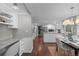 Bright, open kitchen and dining area with hardwood floors and white cabinetry at 3966 S Magnolia Way, Denver, CO 80237