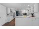 White kitchen featuring an island, stainless steel appliances, and modern lighting at 3966 S Magnolia Way, Denver, CO 80237