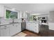 Open concept kitchen with white cabinets and marble countertops connected to the living room at 3966 S Magnolia Way, Denver, CO 80237
