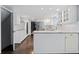 Open concept kitchen with white cabinets, hardwood floors, and stainless steel refrigerator at 3966 S Magnolia Way, Denver, CO 80237