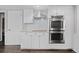 Well-designed kitchen featuring white subway tile backsplash and stainless steel double oven at 3966 S Magnolia Way, Denver, CO 80237